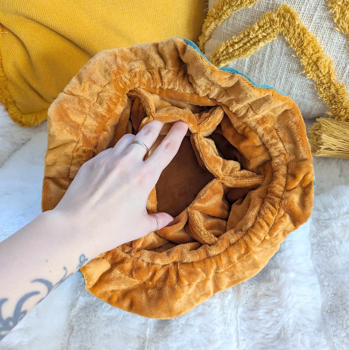 Plush brown multi-pocket dice bag with hand showing interior compartments, soft fabric, and cozy design.