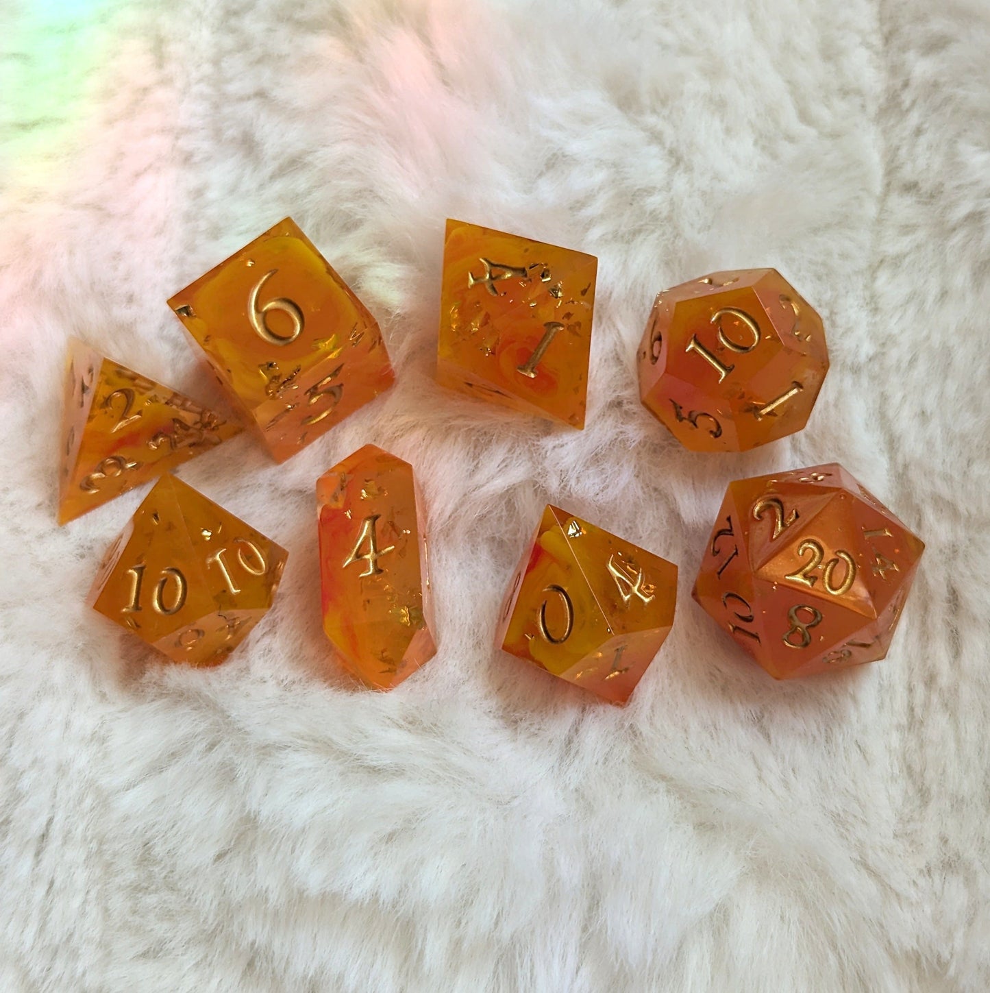 Flame Cast DnD Dice Set with orange, yellow, and red swirl design on plush background, featuring 7 unique hand-poured TTRPG dice.