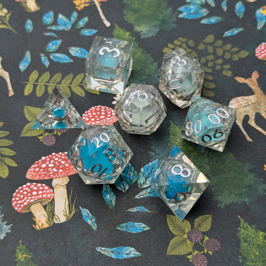 Frostbound Shimmer Liquid Core DnD Dice Set with icy blue glitter, displayed on a forest-themed background.