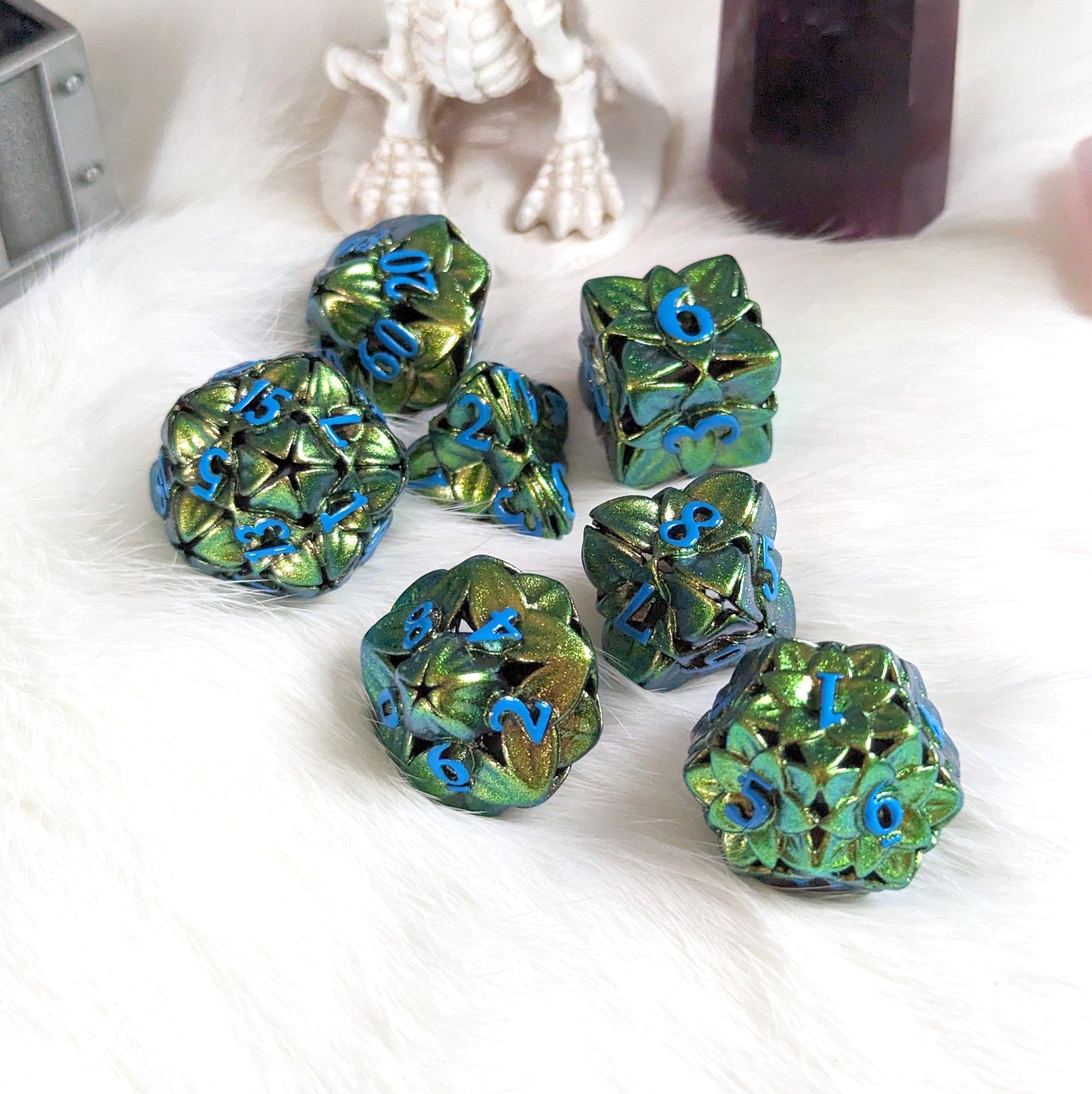 Green floral hollow metal dice set with intricate flower designs for tabletop RPGs like Dungeons and Dragons.