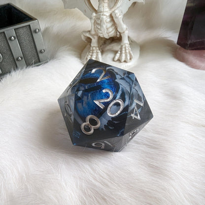 Blue and black Liquid Core Eye Large D20 die on white background with dragon ornament, perfect for Dungeons and Dragons.