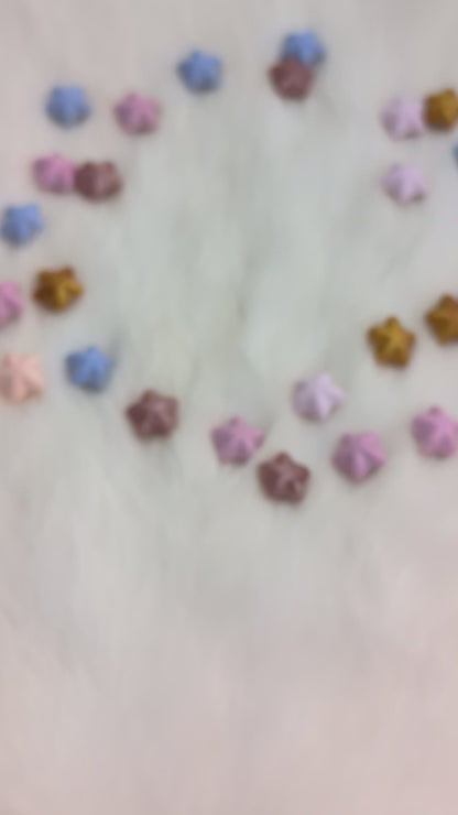 A set of translucent purple polyhedral gaming dice with gold numbering and iridescent glitter, being shook in a hand so you can see the liquid moving on the inside