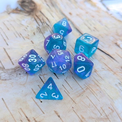 Purple and blue Will O Wisp polyhedral dice set with glittering acrylic finish for tabletop RPGs like Dungeons and Dragons.