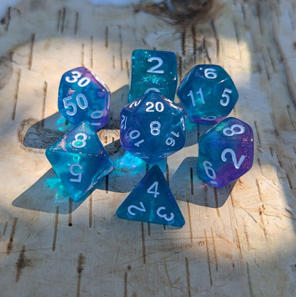 Purple and blue acrylic glitter polyhedral dice set for Dungeons and Dragons, including D20, D12, D10, D%, D8, D6, and D4.