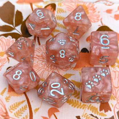 Rose Zephyr 8 piece dice set in clear resin with pearly pink clouds, glitter, silver numbers, featuring custom cat wizard and star designs.