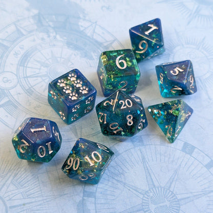 Blue and green opal dice set with gold foil for RPGs, featuring D20, D12, D10, D8, D6, and D4 on a nautical map background.