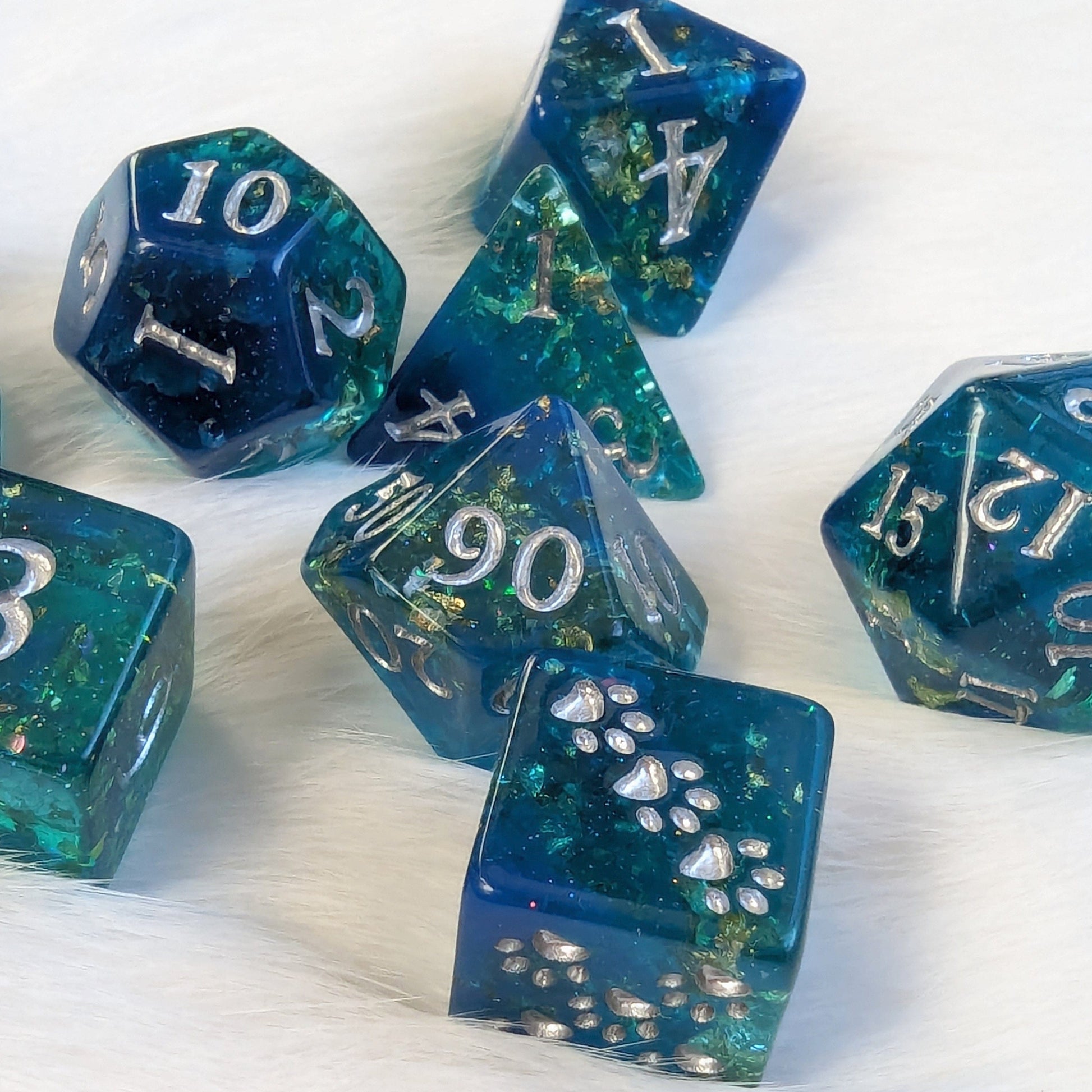 Saltmarsh Dice Set with teal and blue hues, opal flakes, gold foil, and paw D6, designed for Dungeons and Dragons tabletop games.