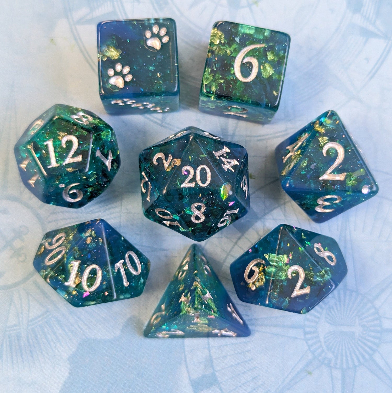 Saltmarsh Dice Set with blue-green opal flakes, gold foil, and paw D6 for Dungeons & Dragons by Fennek and Finch.