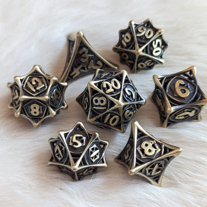 Spider Web Hollow Metal Dice Set with Celtic knot design for Dungeons and Dragons, lightweight polyhedral set on a soft surface.