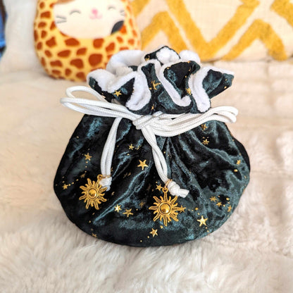 Starry green velvet dice bag with multiple pockets, adorned with golden stars and sun charms, perfect for tabletop gamers.