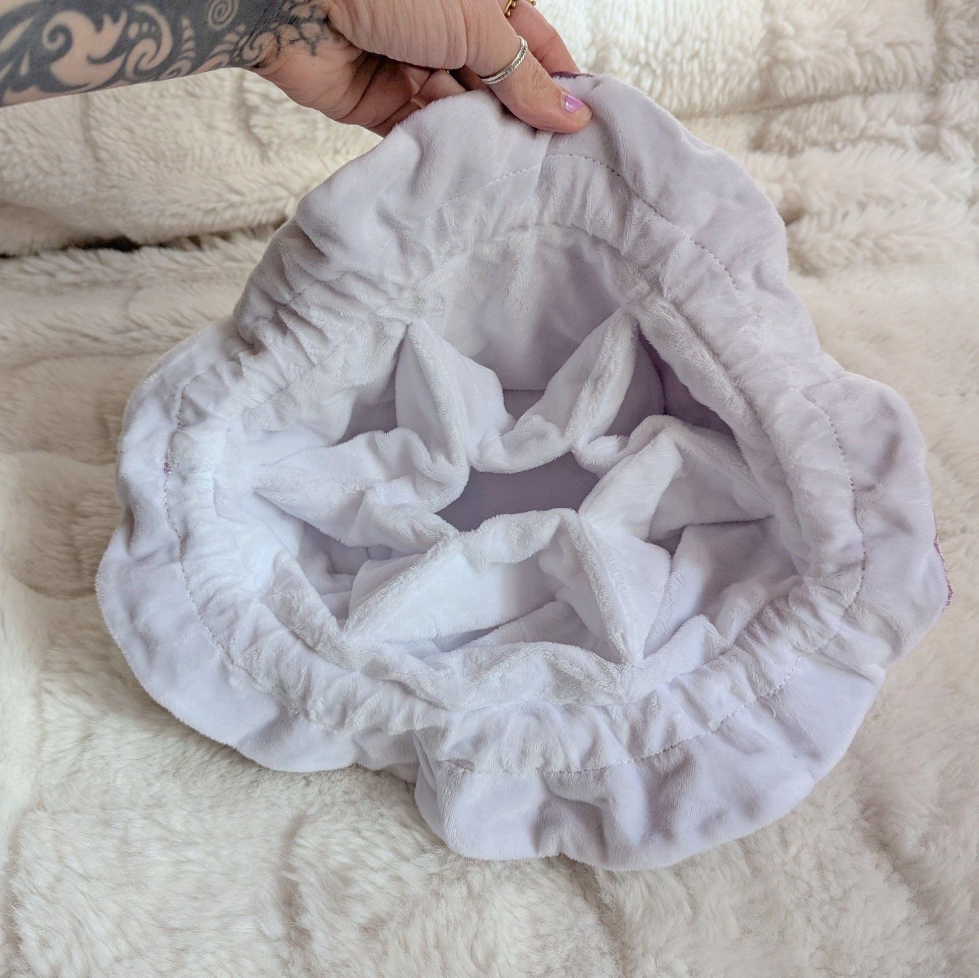 Interior view of the starry mauve dice bag showing multi pocket design and soft white velvety fabric.