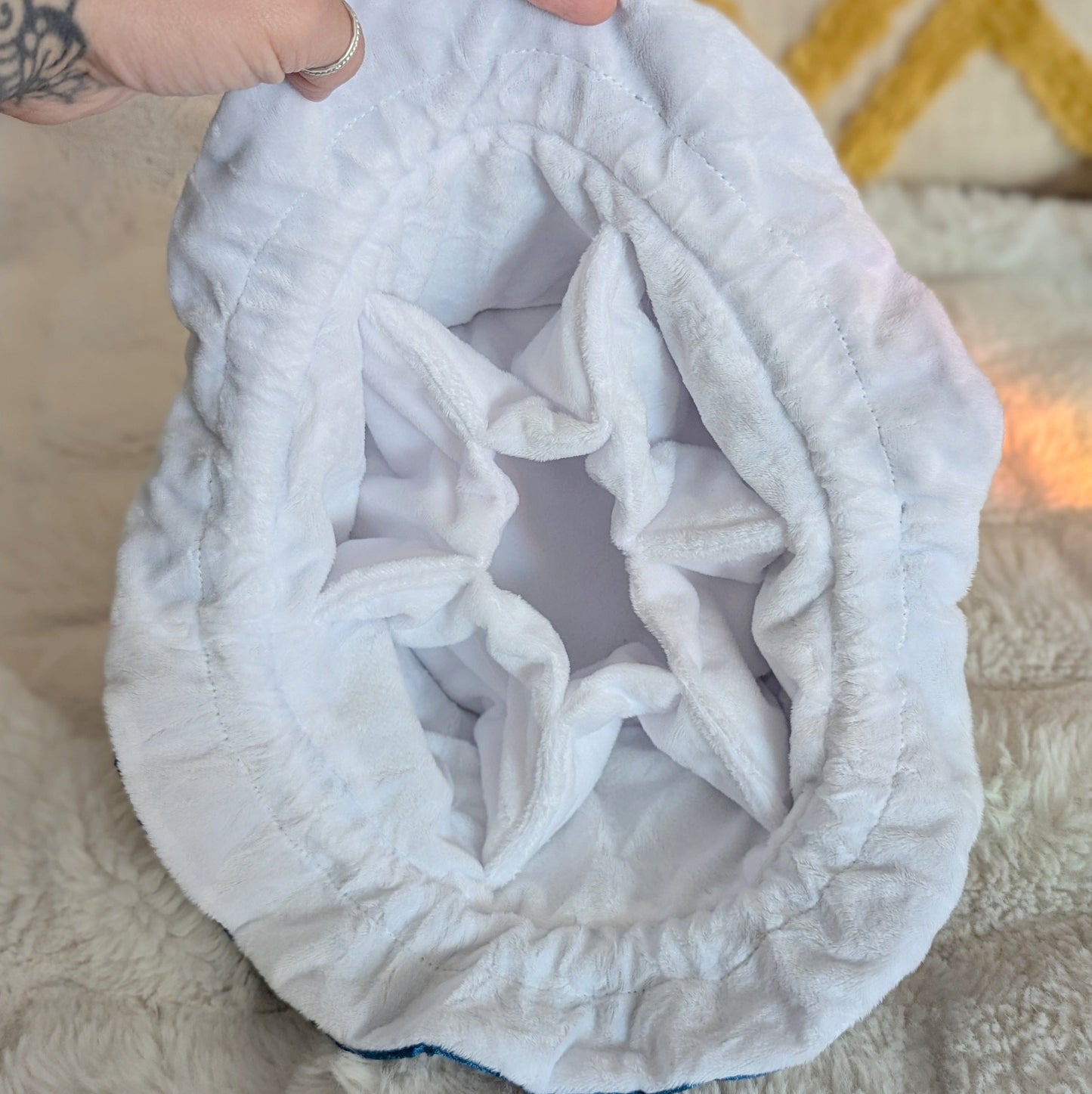 Inside view of a white starry teal dice bag showing the multi-pocket design made with soft velvety fabric.