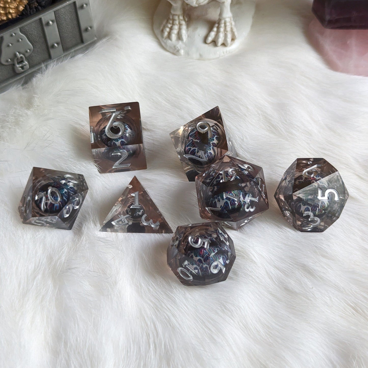 Technicolor Moving Eye Liquid Core Dice Set with swirling colors on fluffy white surface.