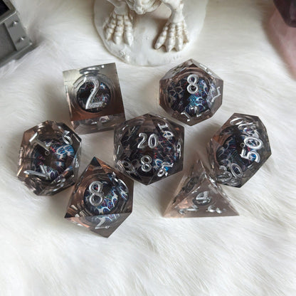 Technicolor Moving Eye Liquid Core Dice Set with swirling colors on a white furry surface.