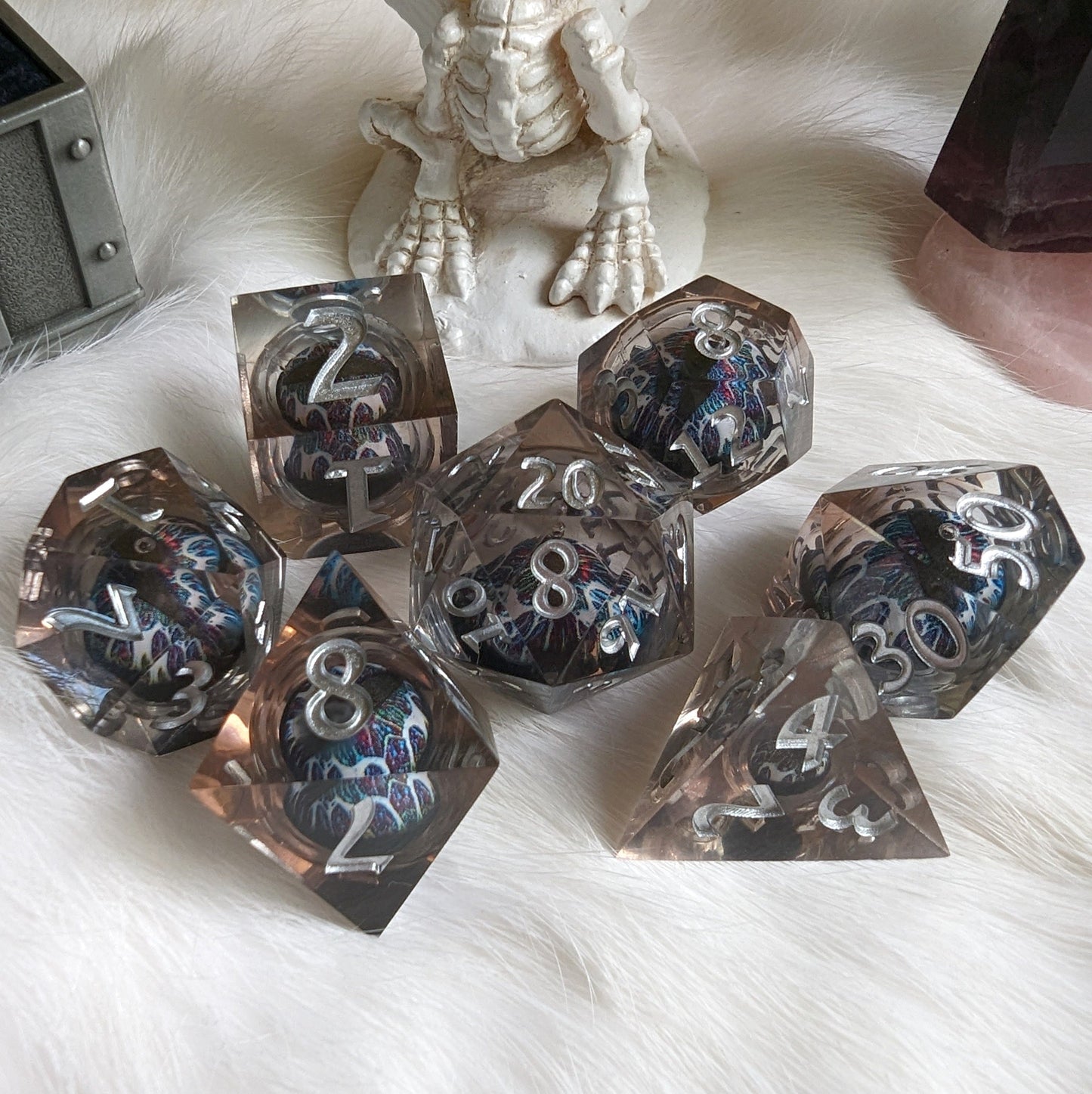 Technicolor Moving Eye Liquid Core Dice Set with swirling colors on a soft surface.