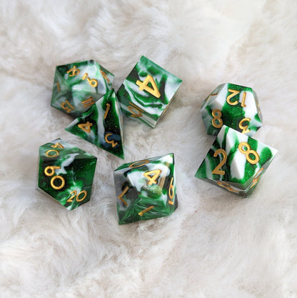 Green and white marbled sharp edge 7-piece resin dice set for Dungeons and Dragons on soft background.