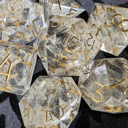 Sharp edge DnD dice set with dandelion seeds and gold numbering on black background, perfect for Druids, Rangers, and Elves.