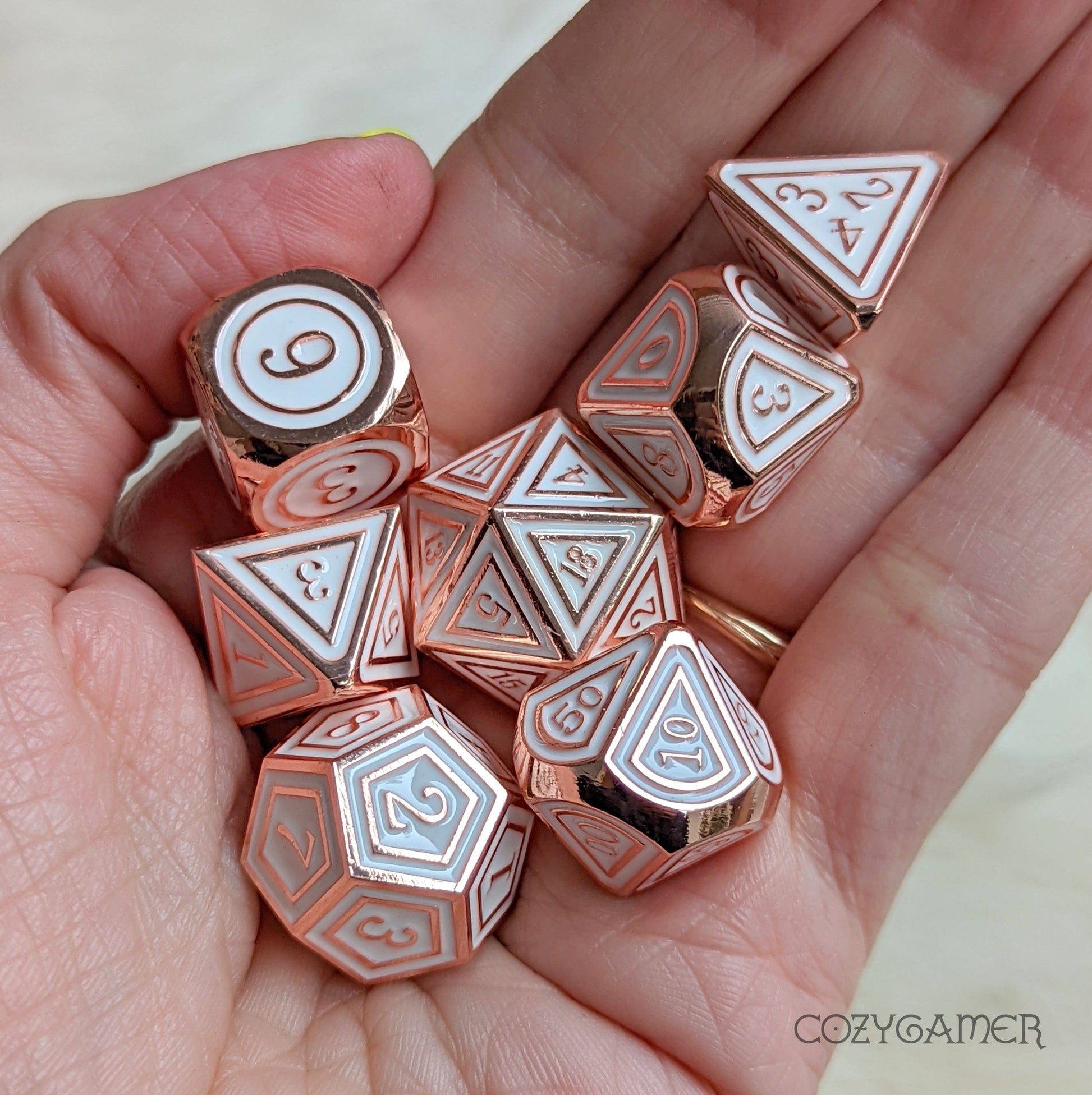 Copper plated Avacyn metal dice set with white enamel, 7-piece polyhedral set for tabletop games like Dungeons and Dragons.