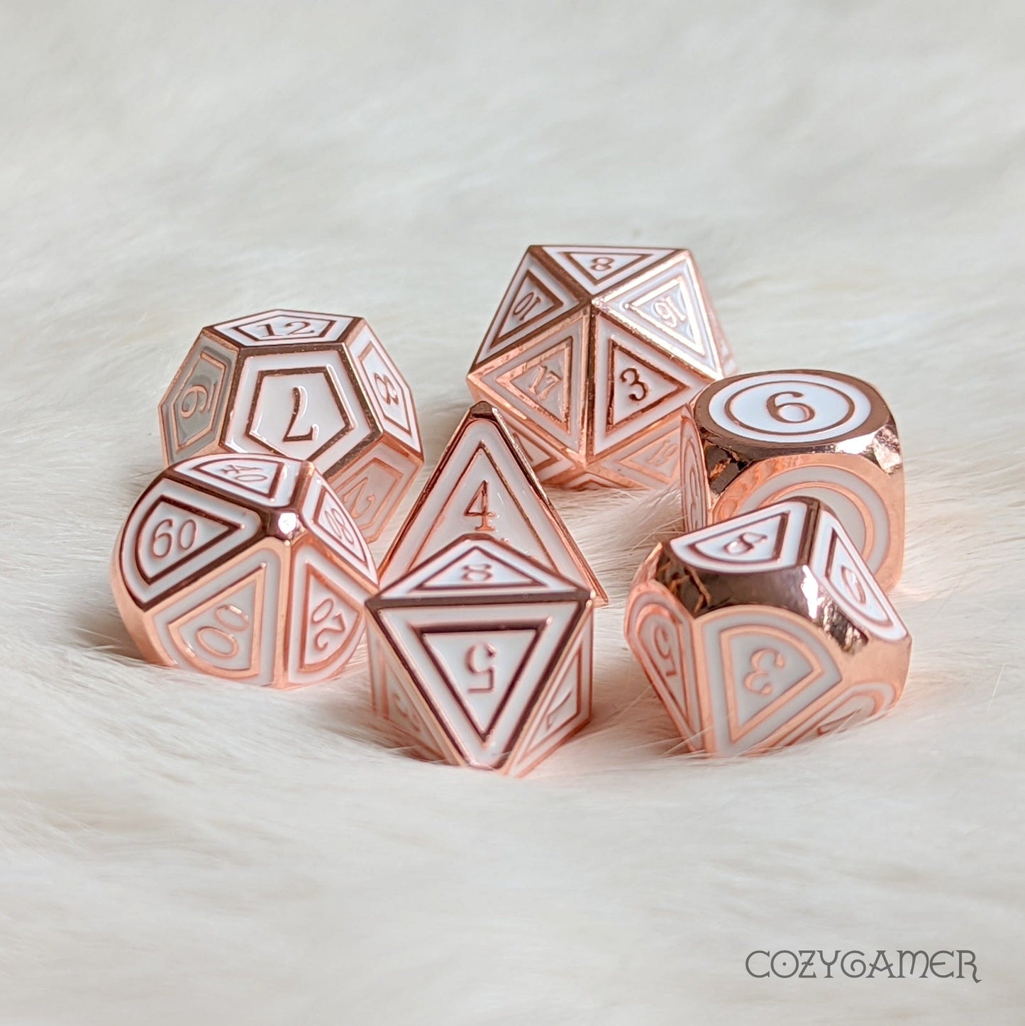 Avacyn copper plated metal dice set with white enamel on soft background, 7-piece polyhedral set for Dungeons and Dragons.