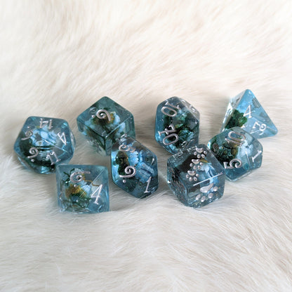 Blue Flower and Moss 8 Piece DND Dice Set with Real Dried Flowers Inside Clear Glittering Resin on White Background