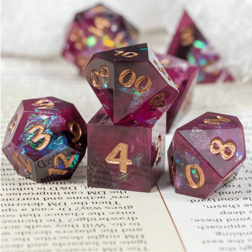 Burgundy and black 7 piece resin dice set with glitter and gold foil, featuring sharp edges for TTRPGs, displayed on paper.