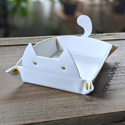 White cat-shaped dice rolling tray for tabletop games, featuring ears and a tail design, laid flat on a wooden surface.