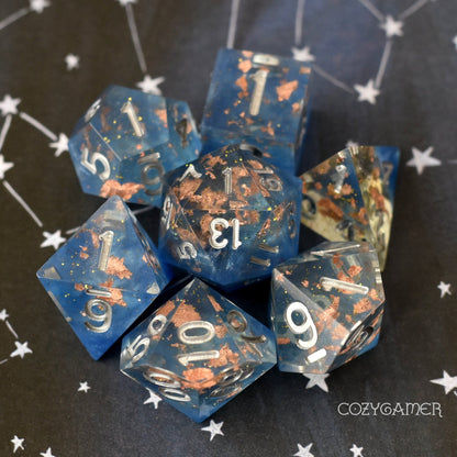 Cloud Palace Sharp Edge Dice Set. Clear resin with copper foil, glitter, and blue clouds