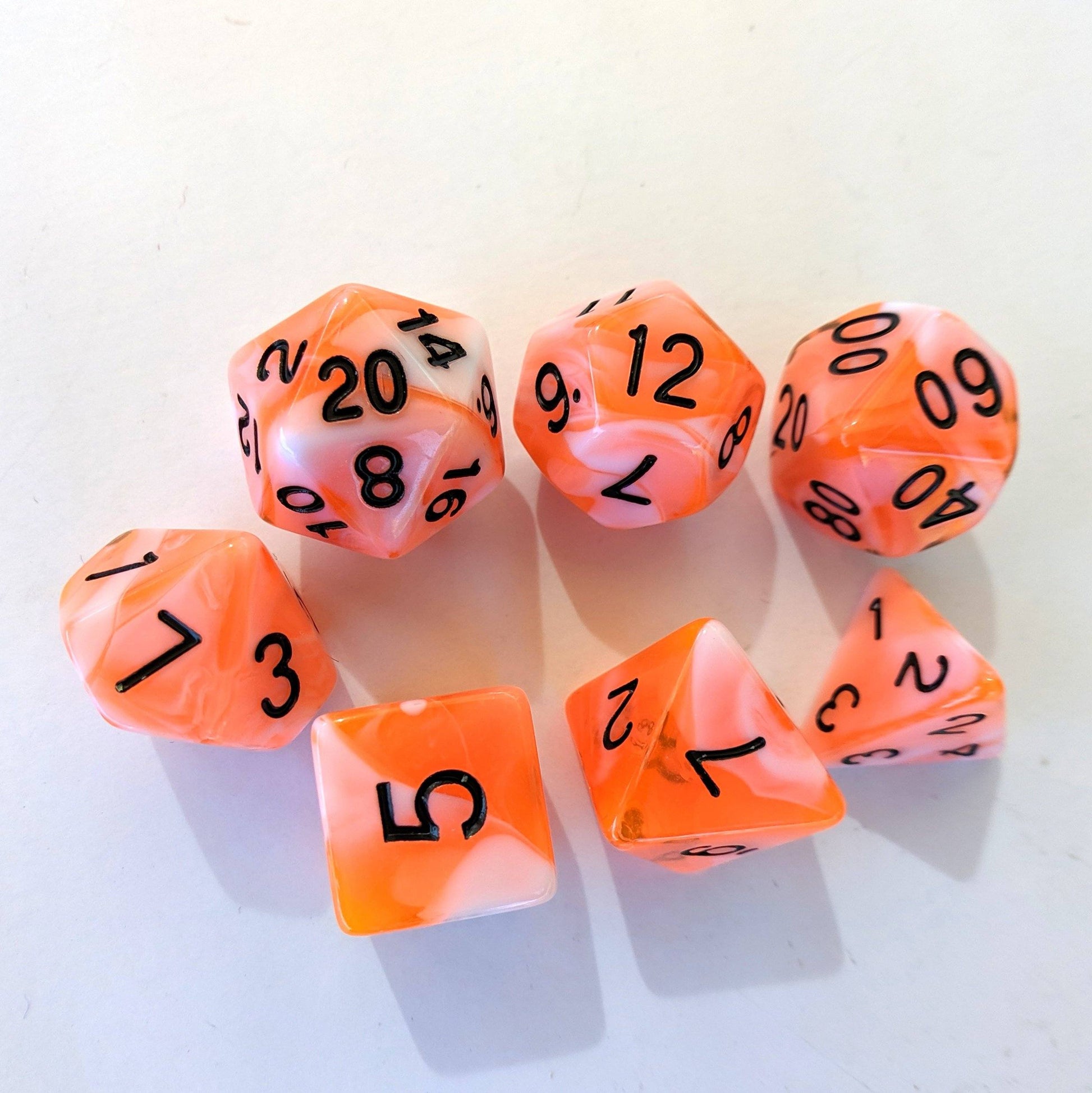 Conflagration DnD Dice Set, 7 polyhedral dice in neon orange and opaque white marble with black numbers for tabletop RPGs.