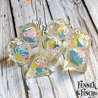 Fae Candy Swirl Dice Set with tiny clay candy in the center, 7 polyhedral pieces for Dungeons and Dragons tabletop games.