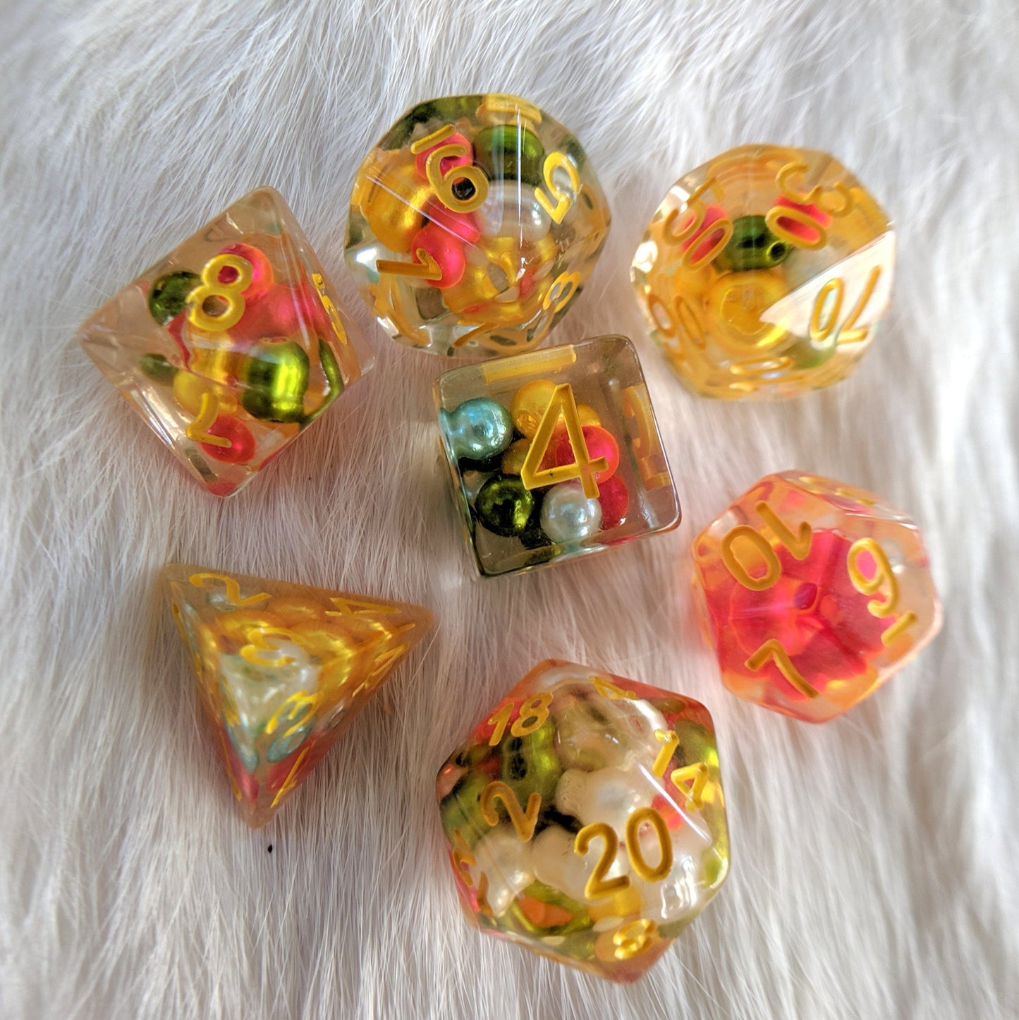 Festive Pearl DnD dice set with colorful beads inside, perfect for tabletop role-playing games.