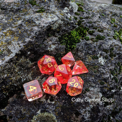 Fire Flick red dice set with clear design and red ink on a mossy rock, perfect for DnD and tabletop RPGs.