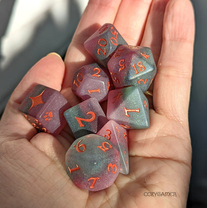 Hand holding Fluorite DnD dice set with purple and green layered matte finish, featuring custom font and orange numbers.