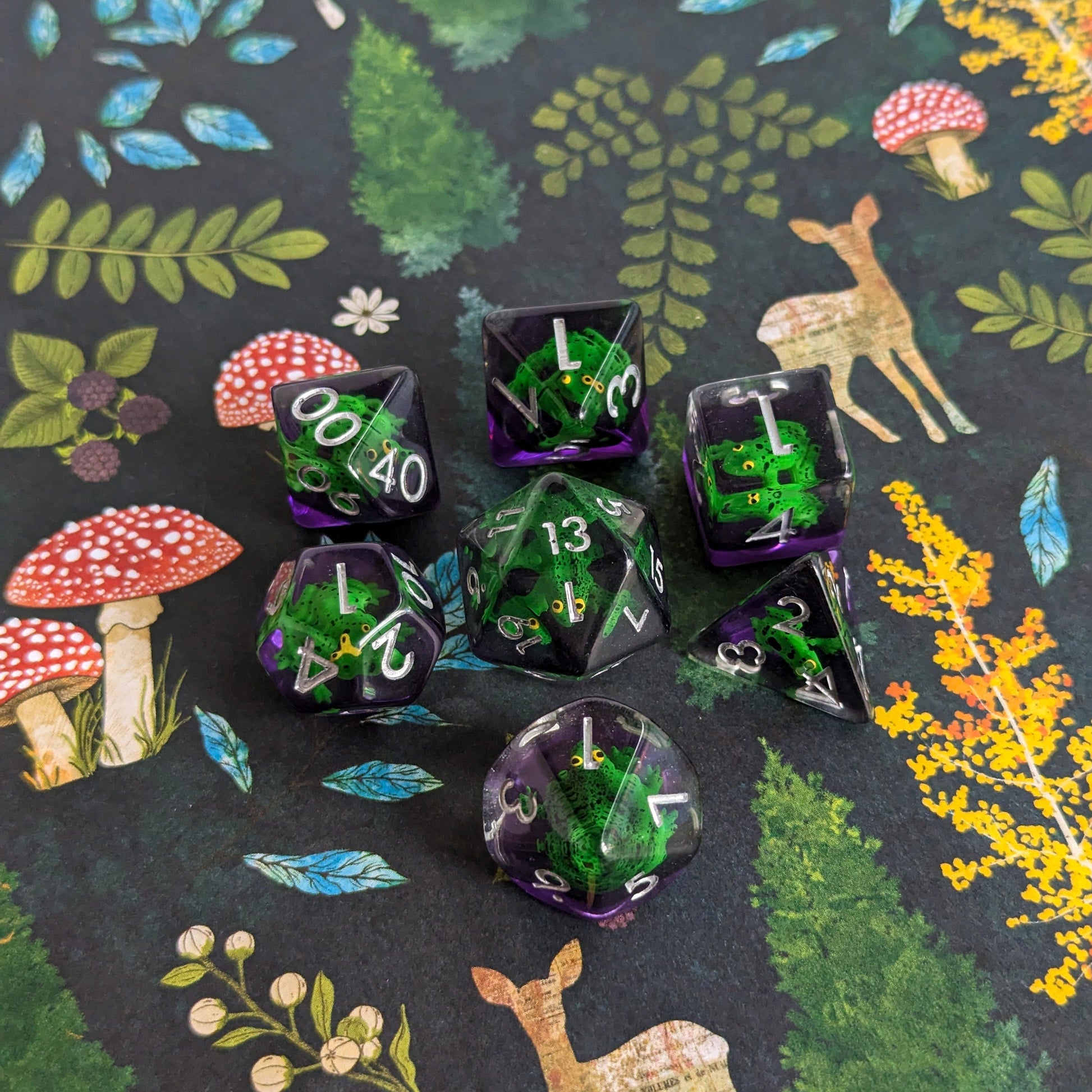 Hoppy Hauntings Frog DnD Dice Set with green frogs on clear purple dice, surrounded by a whimsical nature-themed background.