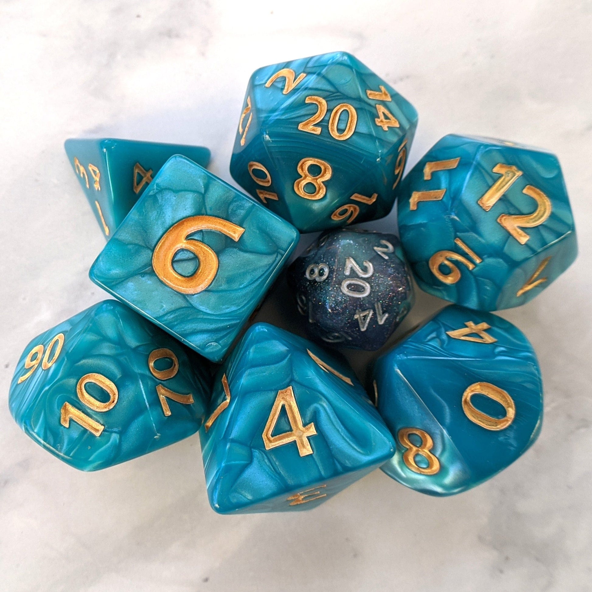 Giant Aquatic Dice Set in pearly blue marble with gold numbers for tabletop games like Dungeons and Dragons.