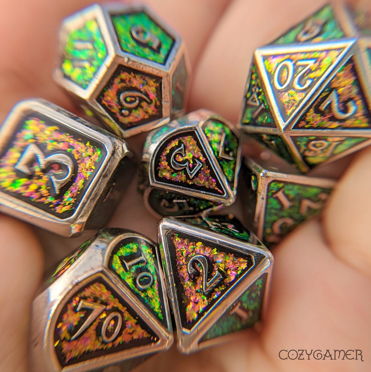Green and pink glitter metal dice set with silver trim for tabletop RPGs, including D20, D12, D10, D%, D8, D6, and D4.