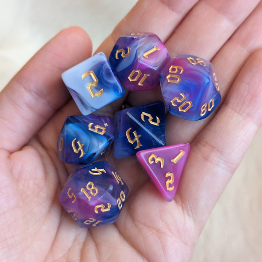 Hand holding marbled white, blue, and purple polyhedral dice set for tabletop games like Dungeons and Dragons.