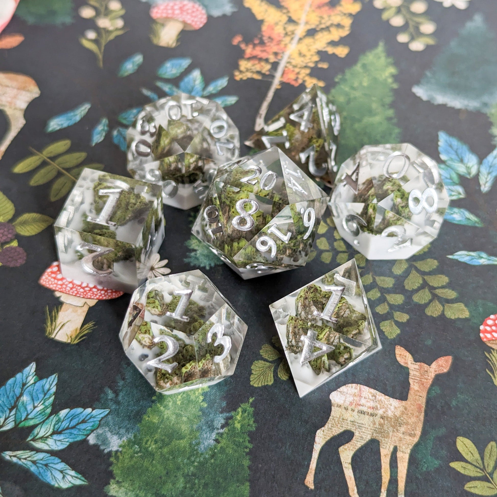 High Peak Sharp Edge Resin DnD Dice Set with mountain peak design on forest-themed background.