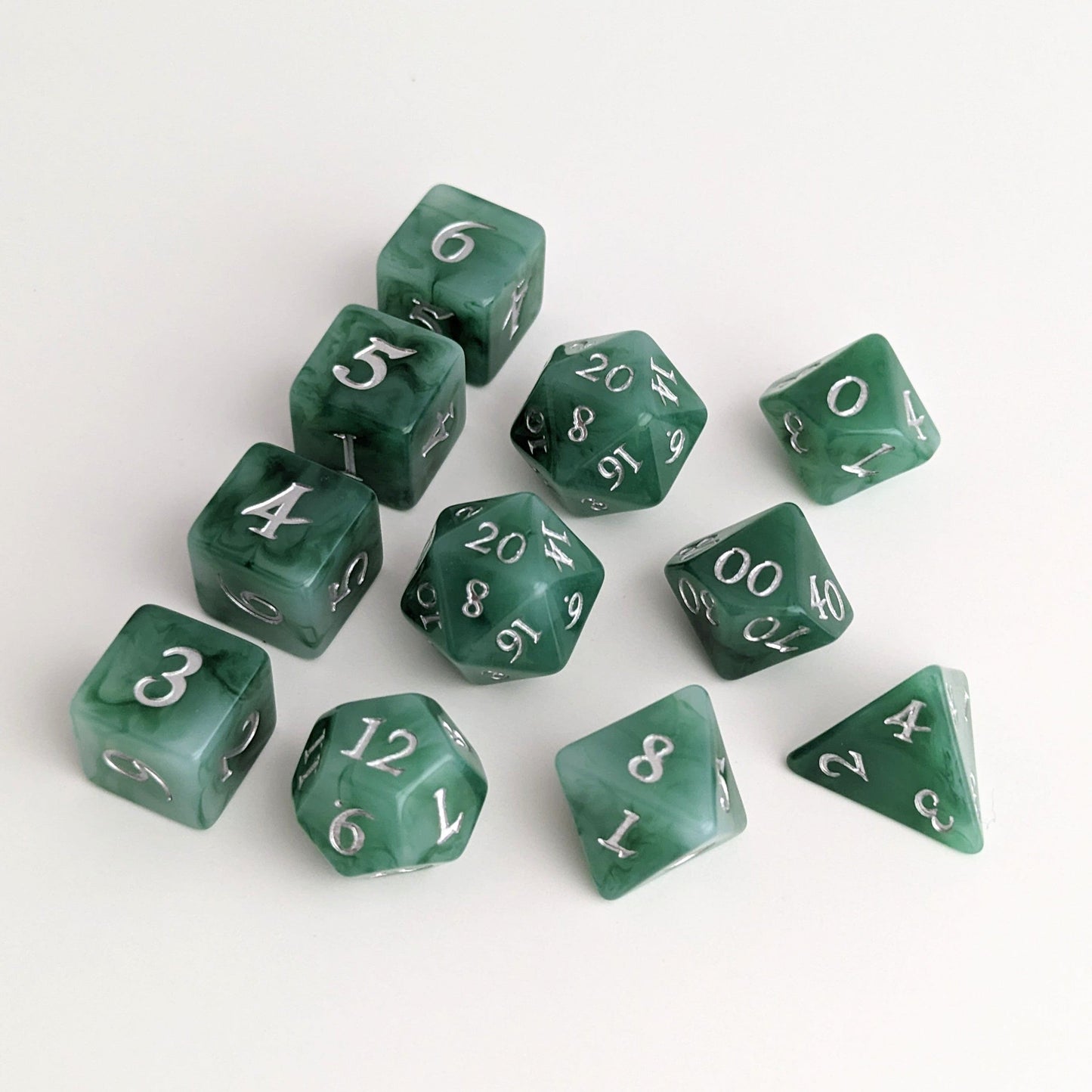 Jade-themed DnD dice set featuring green and white resin with silver numbers, available in 7 and 11 piece configurations.