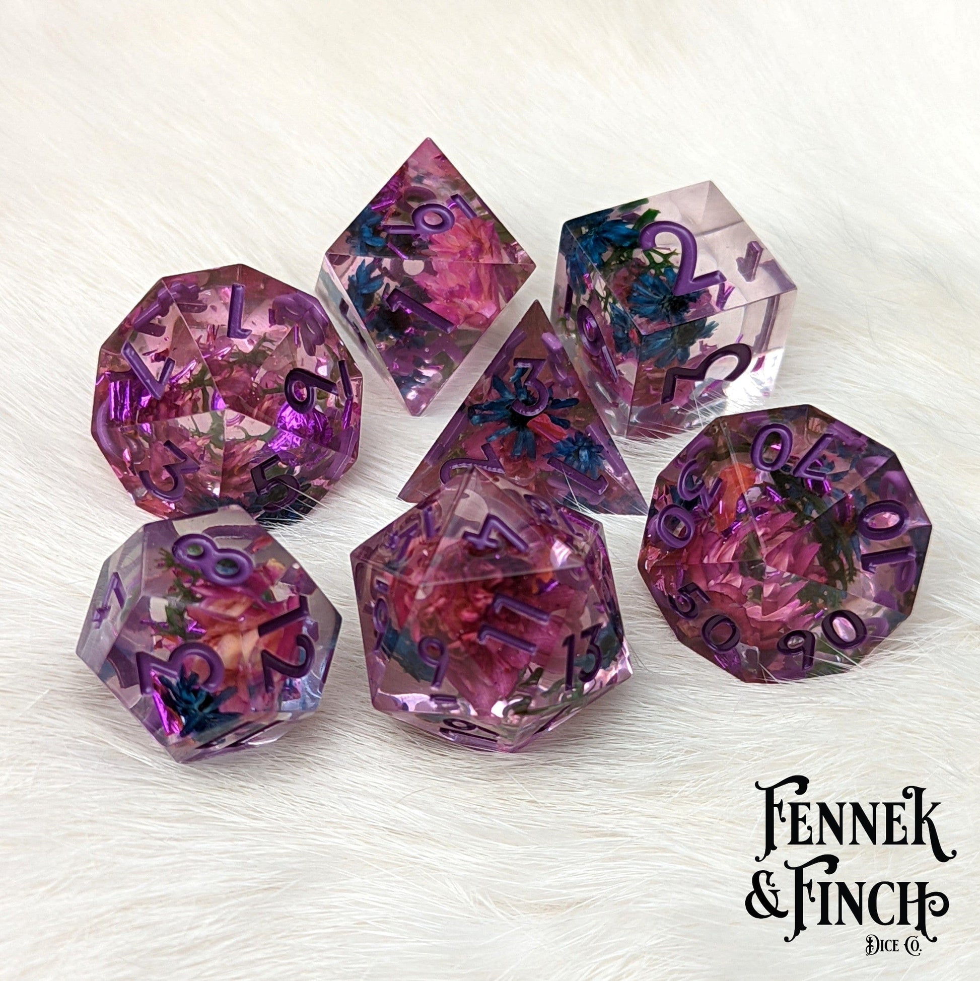 Midnight Garden sharp edge dice set with real dried purple and blue flowers, perfect for Dungeons and Dragons and tabletop games.