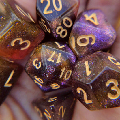 Micro shimmer galaxy dice set in purple, yellow, and brown with pale gold numbers for tabletop games like Dungeons and Dragons.