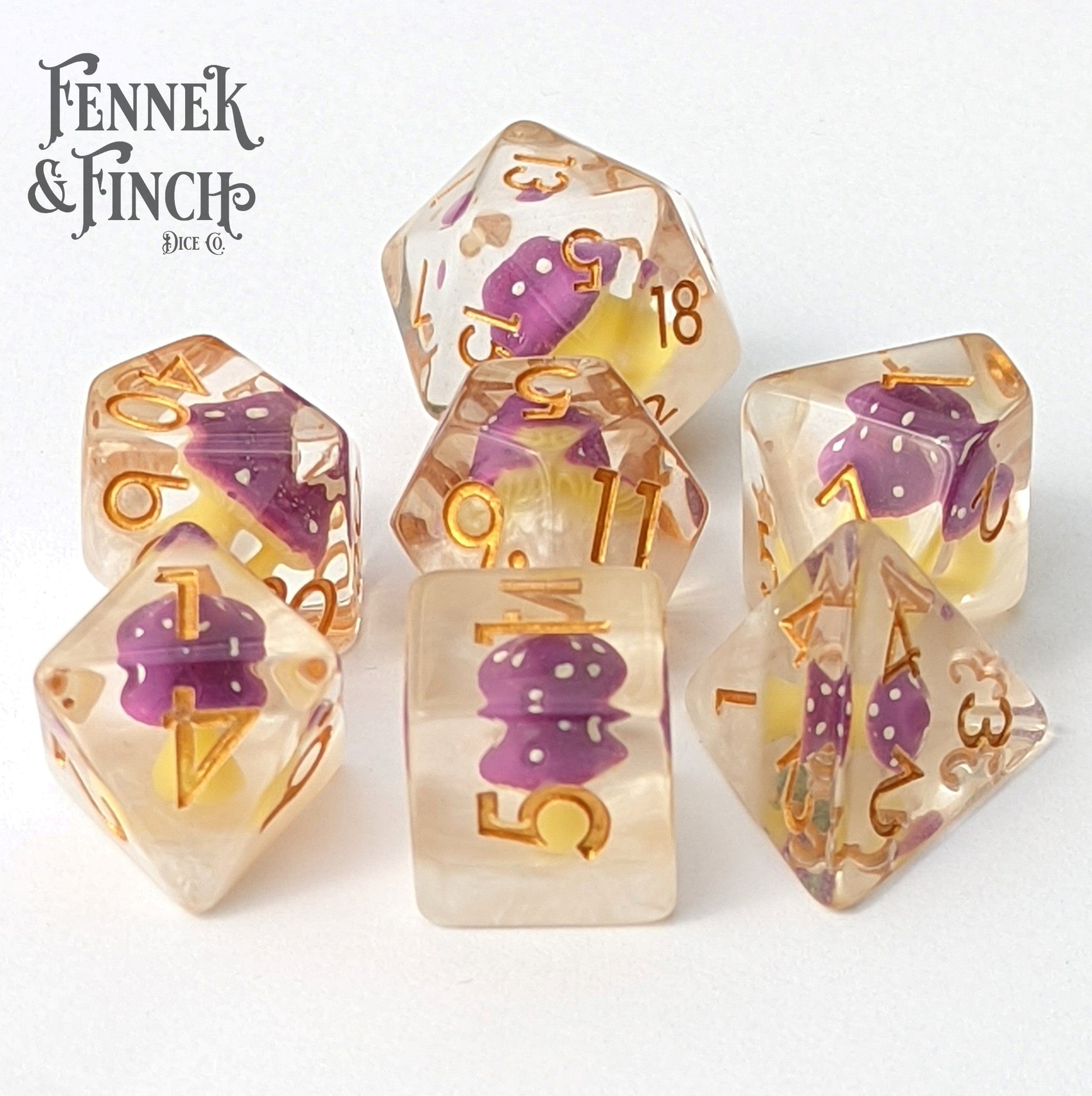 Clear purple mushroom-themed polyhedral dice set with gold numbers, perfect for tabletop games like Dungeons and Dragons.