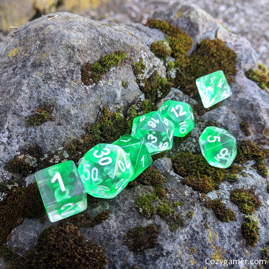 Nature Shift 7 Piece DnD Dice Set with clear green ink resembling water, displayed on mossy rock surface.