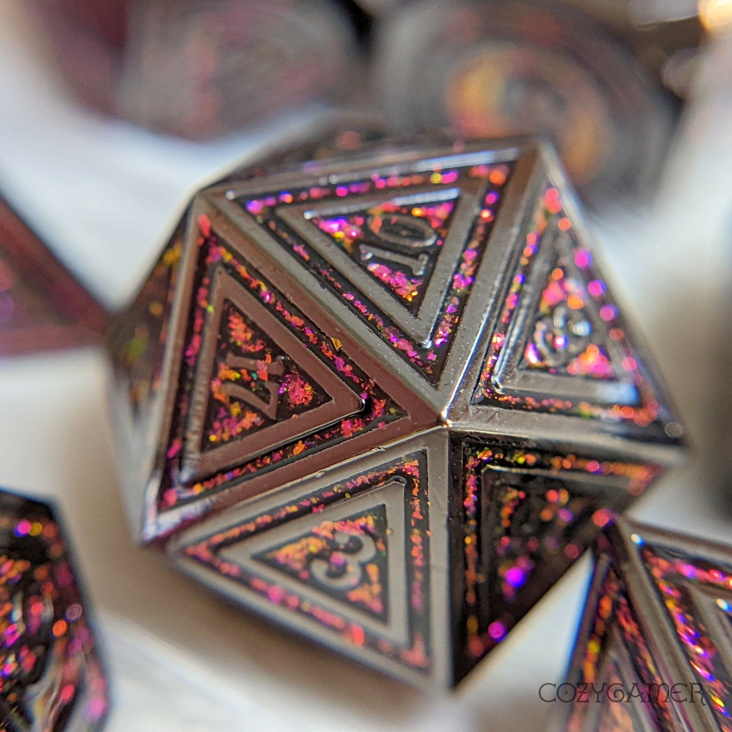 Rainbow Garnet Gate metal dice with black plating and color shifting glitter, perfect for Dungeons and Dragons tabletop gaming.