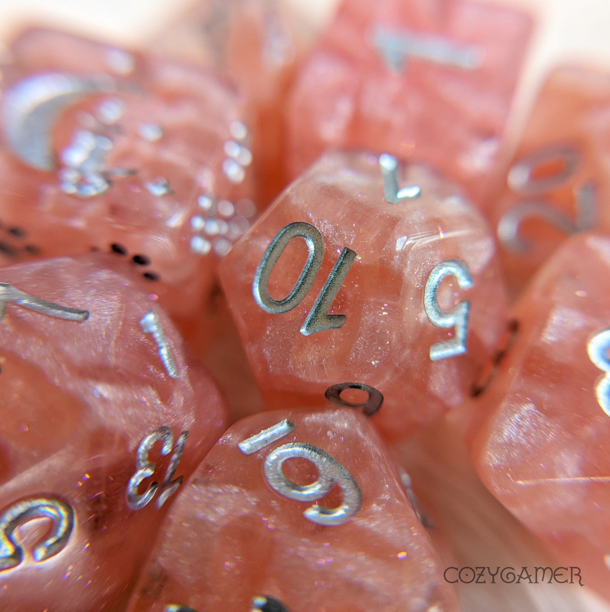 Rose Zephyr 8 Piece Dice Set. Clear resin with pearly pink clouds, glitter, and silver font.