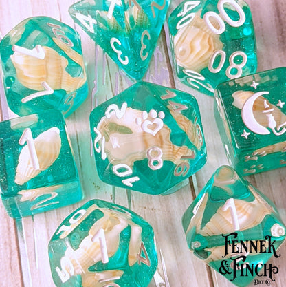 Sea Shell 8 Piece DnD Dice Set with teal glitter resin and white font featuring custom cat wizard and paw heart designs.