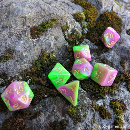 Tulip Dice Set, marbled pearly green and pink polyhedral dice for tabletop role-playing games like Dungeons & Dragons, on mossy rock.